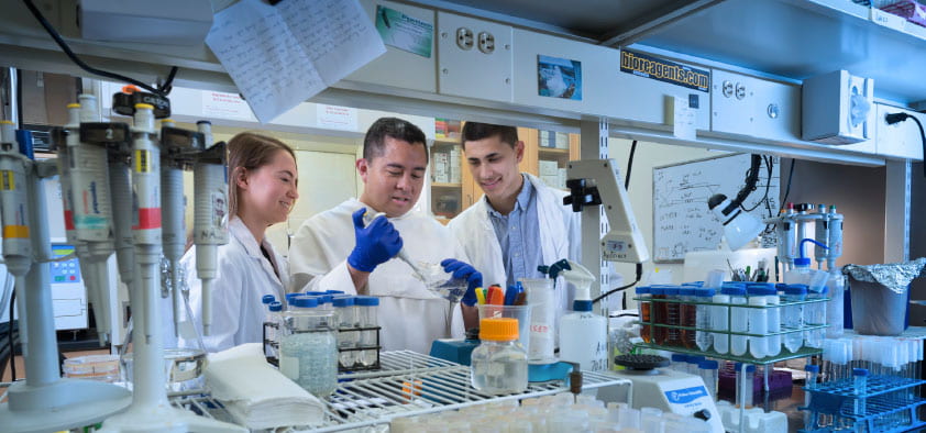 Students working with a Dominican Friar in the lab